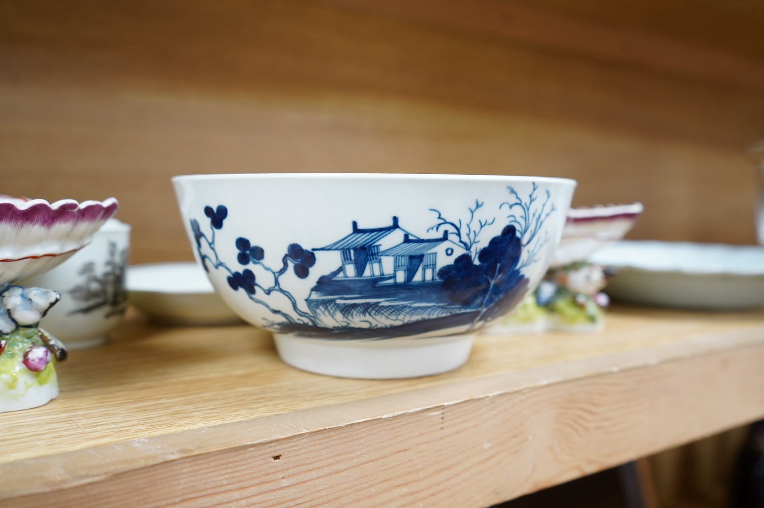 A Worcester coffee cup and saucer, Milkmaid pattern by Hancock, a pair of English porcelain shell salts, and a Worcester blue and white bowl, 18cm (5). Condition - fair